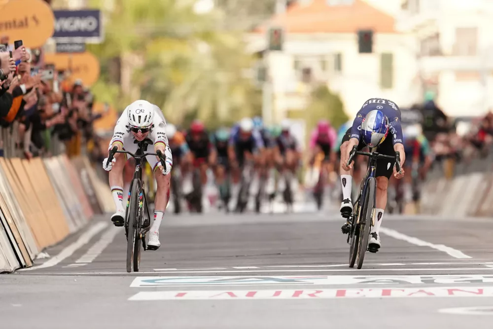 Slovenia's Tadej Pogacar of UAE Team Emirates XRG, left, crosses the finish line ahead of Britain's Thomas Pidcock of Pinarello-Q36.5 Pro Cycling Team, right, to win the men's elite race of the Milano-Sanremo one day cycling race (298 km) from Pavia to Sanremo, Italy, March 21, 2026. (Massimi Paolone/LaPresse via AP)