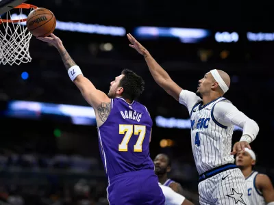 Los Angeles Lakers guard Luka Doncic (77) shoots in front of Orlando Magic guard Jalen Suggs (4) during the first half of an NBA basketball game, Saturday, March 21, 2026, in Orlando, Fla. (AP Photo/Phelan M. Ebenhack)