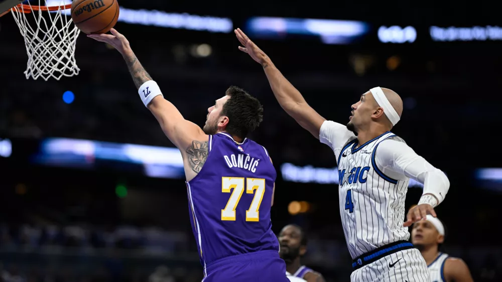 Los Angeles Lakers guard Luka Doncic (77) shoots in front of Orlando Magic guard Jalen Suggs (4) during the first half of an NBA basketball game, Saturday, March 21, 2026, in Orlando, Fla. (AP Photo/Phelan M. Ebenhack)