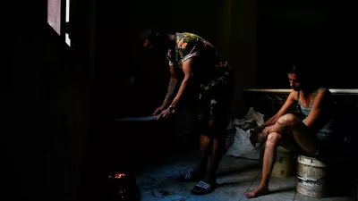 Jesus Rodriguez lights charcoal for cooking while his wife, Yaliet Iglesias, sits nearby as Cuba's national electric grid collapsed for the second time in a week amid the U.S.-imposed oil blockade, according to officials, as the communist government struggles to keep the lights on for about 10 million people with decrepit infrastructure, in Havana, Cuba, March 21, 2026. REUTERS/Norlys Perez