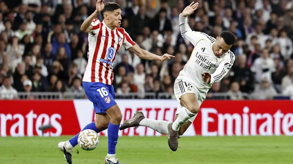 Soccer Football - LaLiga - Real Madrid v Atletico Madrid - Santiago Bernabeu, Madrid, Spain - March 22, 2026 Atletico Madrid's Nahuel Molina in action with Real Madrid's Kylian Mbappe REUTERS/Jon Nazca