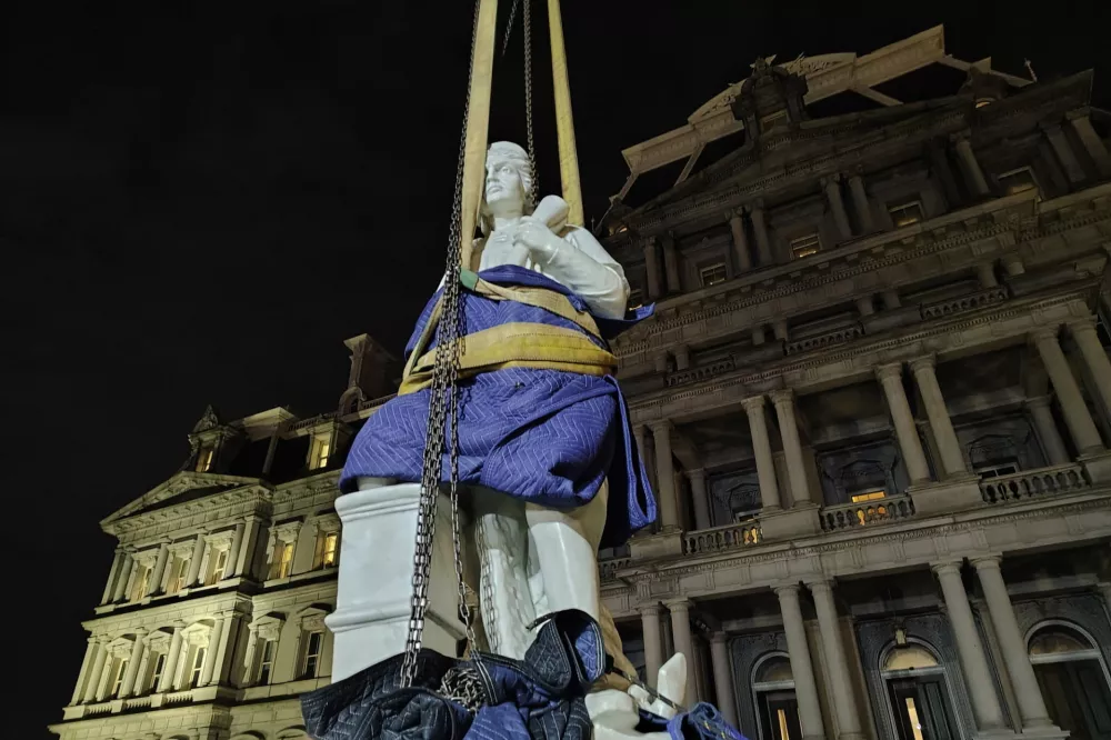 This photo provided by Will Hemsley shows a statue of Christopher Columbus being lowered into place at the Eisenhower Executive Office Building in Washington, Sunday, March 22, 2026. (Will Hemsley via AP)