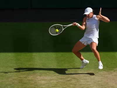 FILE -Iga Swiatek of Poland returns to Amanda Anisimova of the U.S. during the women's singles final match at the Wimbledon Tennis Championships in London, July 12, 2025.(AP Photo/Joanna Chan, File)