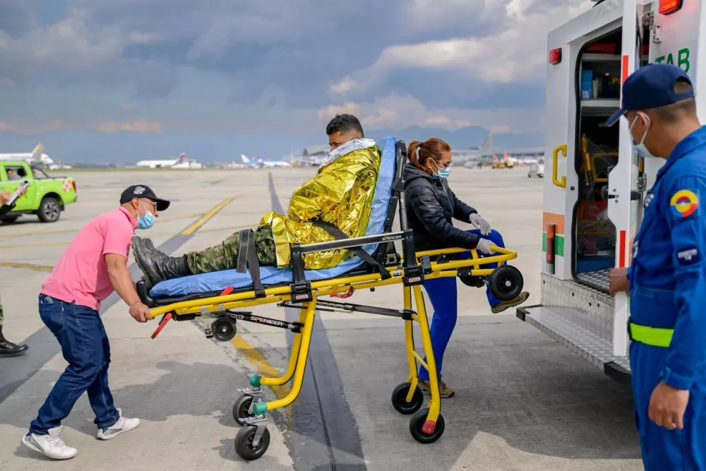 In this photo distributed by Colombia's Armed Forces press office, a solider who was injured on a military cargo plane that crashed shortly after takeoff in Puerto Leguizamo arrives at a military base for treatment in Bogota, Colombia, Monday, March 23, 2026. (Colombia's Armed Forces press office via AP)