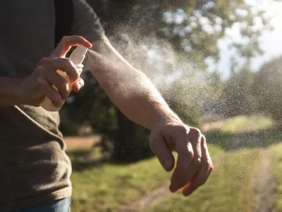 Prevention against mosquito bite during sunny summer day. Man is applying insect repellent on his hand. / Foto: Chalabala Getty Images