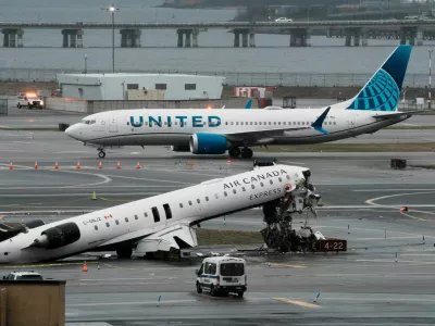A United Airlines aircraft taxis next to the wreckage of an Air Canada Express jet that collided with a fire truck at New York's LaGuardia Airport in Queens, New York, U.S., March 23, 2026. REUTERS/Eduardo Munoz