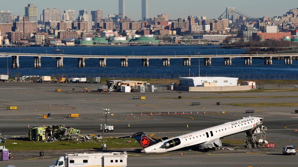 An Air Canada Express jet and Port Authority fire truck lay on the side of a runway at LaGuardia Airport, Tuesday, March 24, 2026, after colliding with each other shortly after the jet landed in New York Sunday night. (AP Photo/Yuki Iwamura)