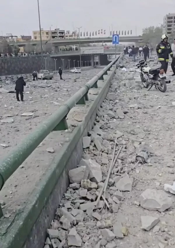 People walk amidst the rubble from the damaged Isfahan Optics Industries building and the surrounding area in Isfahan, Iran, in this&nbsp;screengrab&nbsp;obtained from a social media video released on March 24, 2026. SOCIAL MEDIA/via REUTERS THIS IMAGE HAS BEEN SUPPLIED BY A THIRD PARTY. MANDATORY CREDIT. NO RESALES. NO ARCHIVES. NEWS USE ONLY. Verification lines: Reuters was able to verify the location as Isfahan by the buildings, overpass, signs, road guardrails, walls and road layout seen in the videos which matched file and satellite imagery of the area. Coordinates of the damaged Isfahan Optics Industries building: 32.70324339647984, 51.67593590009293. The date when the videos were filmed was not verified, but no older version of the video was found posted online before March 24. The Iranian Red Crescent said the area was attacked on March 24. / Foto: Social Media
