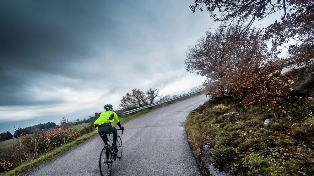 cyclist trains along a mountain road during a stormcyclist are training on a rainy day