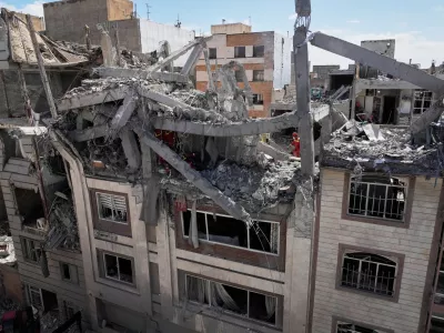 First responders inspect a residential building hit in an earlier U.S.-Israeli strike in Tehran, Friday, March 27, 2026. (AP Photo/Vahid Salemi)