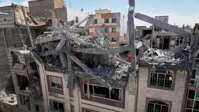 First responders inspect a residential building hit in an earlier U.S.-Israeli strike in Tehran, Friday, March 27, 2026. (AP Photo/Vahid Salemi)