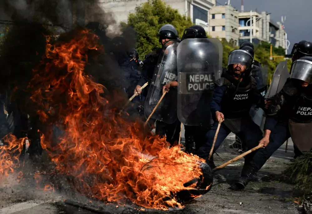 Police attempt to clear a flaming tyre during a protest by supporters of Nepal's former Prime Minister and chairman of the Communist Party of Nepal (Unified Marxist&ndash;Leninist) K.P. Sharma Oli, following his detention by police, who are investigating whether he was negligent in preventing dozens of deaths during the Gen Z protests, in Kathmandu, Nepal, March 28, 2026. REUTERS/Navesh Chitrakar REFILE - CLARIFYING PARTY NAME