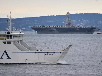 A Croatian ferryboat sails by as USS Gerald R. Ford arrives to the port of Split, Croatia, Saturday, March 28, 2026. (AP Photo/Tom Dubravec)