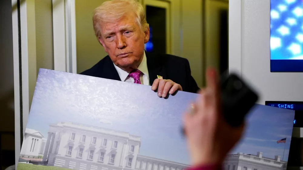 A member of the media raises her hand for a question as U.S. President Donald Trump talks while holding up renderings of the planned White House ballroom, aboard Air Force One en route to Joint Base Andrews, Maryland, U.S., March 29, 2026. REUTERS/Elizabeth Frantz