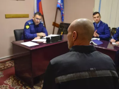 In this photo released by Human rights ombudsman of Yamalo-Nenets Autonomous District on Friday, Dec. 15, 2023, a group of officers listen to a prisoner, back to a camera, as they visit a prison colony in the town of Kharp, in the Yamalo-Nenetsk region about 1,900 kilometers (1,200 miles) northeast of Moscow. Associates of imprisoned Russian opposition leader Alexei Navalny say he has been located at a prison colony above the Arctic Circle nearly three weeks after contact with him was lost. (The Russian Federal Penitentiary Service via AP)