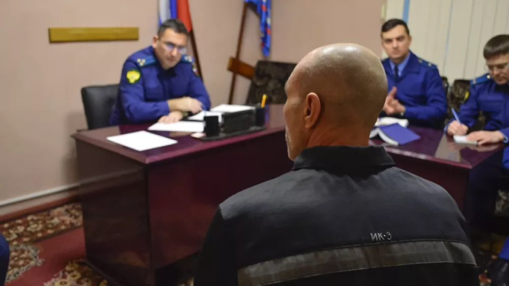 In this photo released by Human rights ombudsman of Yamalo-Nenets Autonomous District on Friday, Dec. 15, 2023, a group of officers listen to a prisoner, back to a camera, as they visit a prison colony in the town of Kharp, in the Yamalo-Nenetsk region about 1,900 kilometers (1,200 miles) northeast of Moscow. Associates of imprisoned Russian opposition leader Alexei Navalny say he has been located at a prison colony above the Arctic Circle nearly three weeks after contact with him was lost. (The Russian Federal Penitentiary Service via AP)