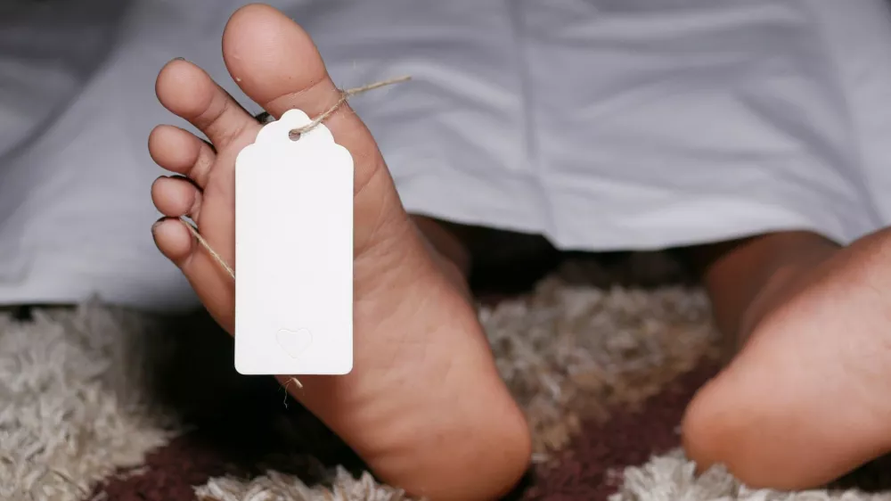 The dead man's body with tag on feet under white cloth in a morgue.,Image: 668558601, License: Royalty-free, Restrictions:, Model Release: no