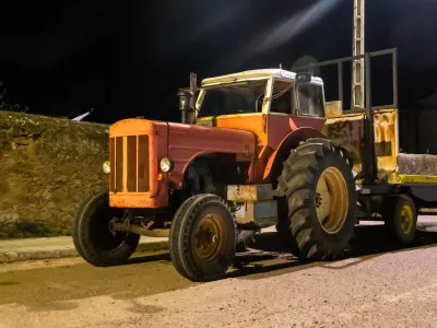Night photograph of an old red tractor under artificial lighting.