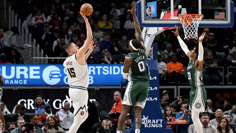 Mar 16, 2023; Detroit, Michigan, USA; Denver Nuggets center Nikola Jokic (15) shoots the ball over Detroit Pistons center Jalen Duren (0) and Detroit Pistons guard Jaden Ivey (23) in the fourth quarter at Little Caesars Arena. Mandatory Credit: Lon Horwedel-USA TODAY Sports
