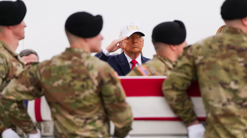 FILE - President Donald Trump salutes as an Army carry team moves a flag-draped transfer case with the remains of Sgt. Declan Coady, 20, of West Des Moines, Iowa, who was killed in a drone strike at a command center in Kuwait after the U.S. and Israel launched their military campaign against Iran, during a casualty return, March 7, 2026, at Dover Air Force Base, Del. (AP Photo/Julia Demaree Nikhinson, File)