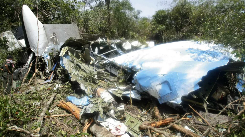 A Cambodian search and rescue official inspects the wreckage of an 44-seat Antonov AN-24 plane on June 27, 2007, which crashed into a jungle-clad mountain150 km (90 miles) southwest of Phnom Penh. Searchers found the wreckage of the plane carrying 22 people, including 13 Koreans and three Czechs, high on the Cambodian mountain on Wednesday but there were no survivors. REUTERS/Stringer (CAMBODIA)