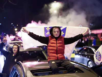 Bosnian fans wave flags as they celebrate after the Bosnian national team qualified for the World Cup by winning a penalty shootout against Italy, in Zenica, Bosnia, Wednesday, April 1, 2026. (AP Photo/Armin Durgut)