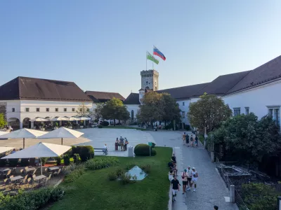 Ljubljana, Slovenia - August 11, 2025: Courtyard of historical and symbolic Ljubljana Castle with national and city flags flying high on the tower, Ljubljana, Slovenia. Tourist attraction.