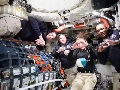 This image taken from video provided by NASA shows the Artemis II crew Commander Reid Wiseman, second from left, thanking the families of the crew while speaking with NASA Mission Control via video conference from the moon's orbit as Canadien astronaut and mission specialist Jeremy Hansen, far left, looks on and mission specialist Christina Koch and pilot Victor Glover, far right, make hearts with their hands Thursday, April 2, 2026. (NASA via AP)