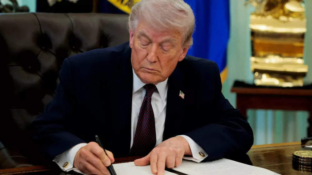FILE PHOTO: U.S. President Donald Trump signs an executive order on mail ballots, in the Oval Office of the White House in Washington, D.C., March 31, 2026. REUTERS/Evan Vucci/File Photo