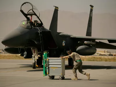 FILE - A U.S. Air Force airman pushes a cart past an F-15E Strike Eagle at Bagram Air Field in Afghanistan on Oct. 17, 2009. (AP Photo/Maya Alleruzzo, File)
