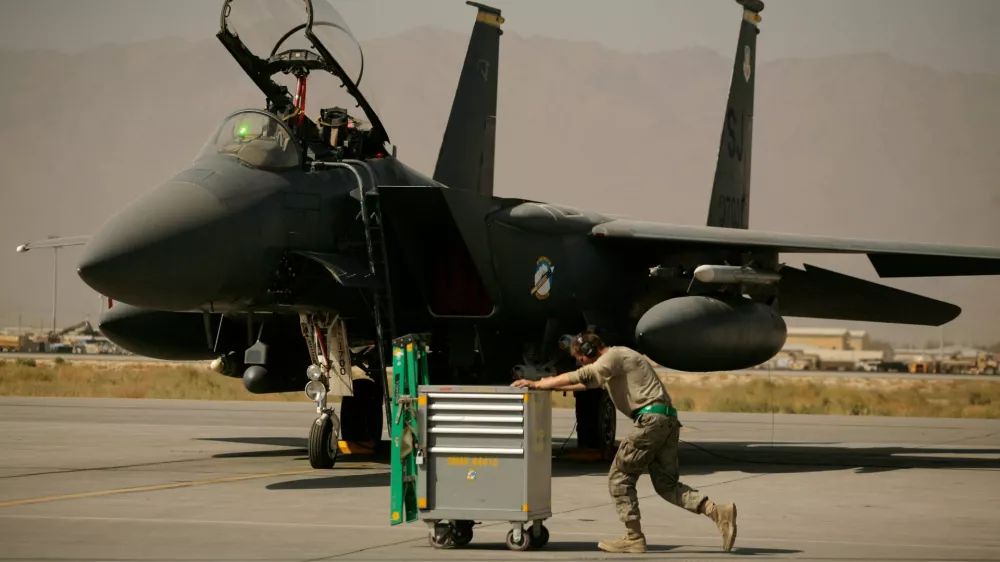 FILE - A U.S. Air Force airman pushes a cart past an F-15E Strike Eagle at Bagram Air Field in Afghanistan on Oct. 17, 2009. (AP Photo/Maya Alleruzzo, File)