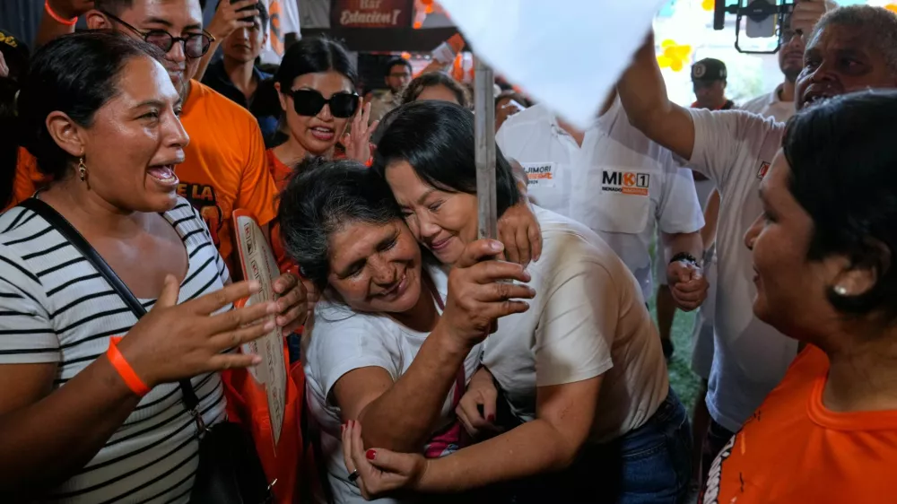 Presidential candidate Keiko Fujimori of the Popular Force party, center, embraces a supporter during a campaign rally in the San Juan de Lurigancho neighborhood of Lima, Peru, Thursday, April 2, 2026. (AP Photo/Martin Mejia)