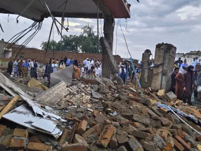 Local residents look at a damaged area of a police station after an overnight deadly bombing in the Bannu district of northwestern Pakistan, Friday, April 3, 2026. (AP Photo/Amaad Khattak)
