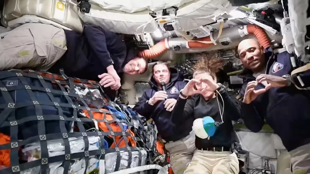 This image from video provided by NASA shows the Artemis II crew Commander Reid Wiseman, second from left, thanking the families of the crew while speaking with NASA Mission Control in a video conference while en route to the moon, Thursday, April 2, 2026, as Canadian astronaut and mission specialist Jeremy Hansen, far left, looks on and mission specialist Christina Koch and pilot Victor Glover, far right, make hearts with their hands. (NASA via AP) CORRECTION: headed to the moon, not in moon's orbit
