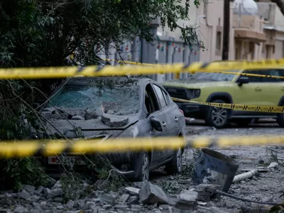 A wrecked car near damaged buildings at the site of an impact of what Bahrain's Ministry of Interior (MOI) said was falling debris of an intercepted Iranian drone last night, amid the U.S.-Israeli conflict with Iran, in Sitra, Bahrain, April 4, 2026. REUTERS/Hamad I Mohammed   TPX IMAGES OF THE DAY