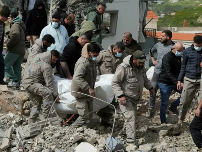 Rescuers carry a dead body at the site of Israeli strike, amid escalating hostilities between Israel and Hezbollah, as the U.S.-Israeli conflict with Iran continues, in Kfar Hatta in southern Lebanon, April 5, 2026. REUTERS/Stringer   TPX IMAGES OF THE DAY