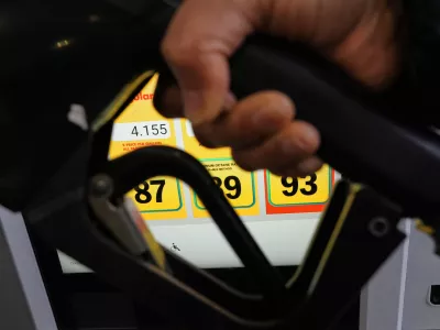 A person fills up her vehicle's gas tank at a gas station in Buffalo Grove, Ill., Thursday, April 2, 2026. (AP Photo/Nam Y. Huh)