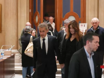 Former French President Nicolas Sarkozy and his wife Carla Bruni-Sarkozy leave the appeals courthouse in Paris, France, Tuesday, April 7, 2026, during his trial appealing a conviction involving illegal campaign funds from Libya. (AP Photo/Thibault Camus)