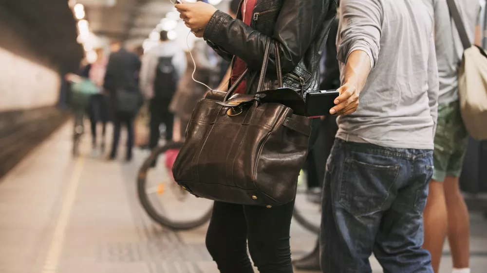 Thief stealing wallet from purse of a woman using mobile phone at the subway station. Pickpocketing at subway station / Foto: Jacoblund Getty Images/istockphoto