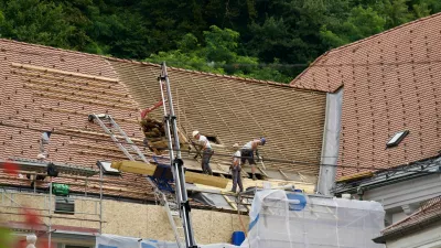 Roofers doing renovation work on rooftop at the old town of City of Ljubljana on a cloudy summer day. Photo taken August 9th, 2023, Ljubljana, Slovenia. / Foto: Michael Derrer Fuchs