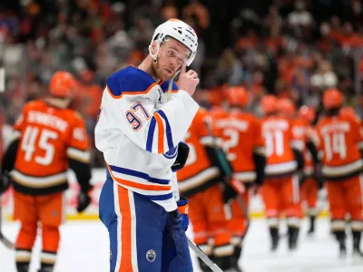 Edmonton Oilers center Connor McDavid wipes his visor as members of the Anaheim Ducks celebrate after they were defeated in Game 6 in the first round of the NHL hockey Stanley Cup playoffs series Thursday, April 30, 2026, in Anaheim, Calif. (AP Photo/Mark J. Terrill) / Foto: Mark J. Terrill