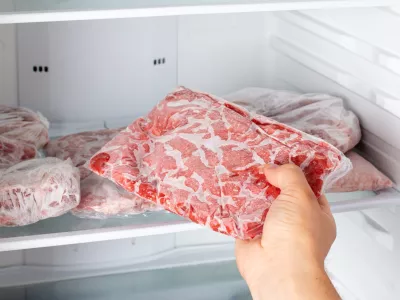 Man taking out frozen meat from freezer. Frozen food