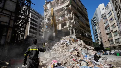 Lebanese civil defense worker gestures to an excavator as they search for victims in the rubbles at the site of a building destroyed in an Israeli airstrike a day earlier in central in Beirut, Lebanon, Thursday, April 9, 2026. (AP Photo/Hussein Malla)