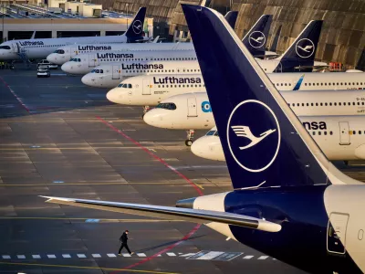 A man walks past parked Lufthansa aircraft at the airport as Lufthansa pilots are on a two-day strike, in Frankfurt, Germany, Thursday, March 12, 2026. (AP Photo/Michael Probst)