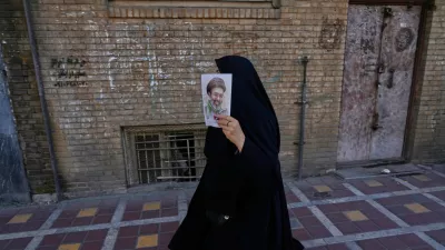 A woman carries a poster depicting Iran's Supreme Leader Ayatollah Mojtaba Khamenei as government supporters gather to mark the 40th day since the killing of his father Supreme Leader Ayatollah Ali Khamenei, in Tehran, Iran, Thursday, April 9, 2026. (AP Photo/Vahid Salemi)