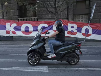 A scooter passes by a billboard reading: ''Kosovo'', placed on a street in front of the government building in Belgrade, Serbia, Thursday, Sept. 18, 2025. (AP Photo/Darko Vojinovic)