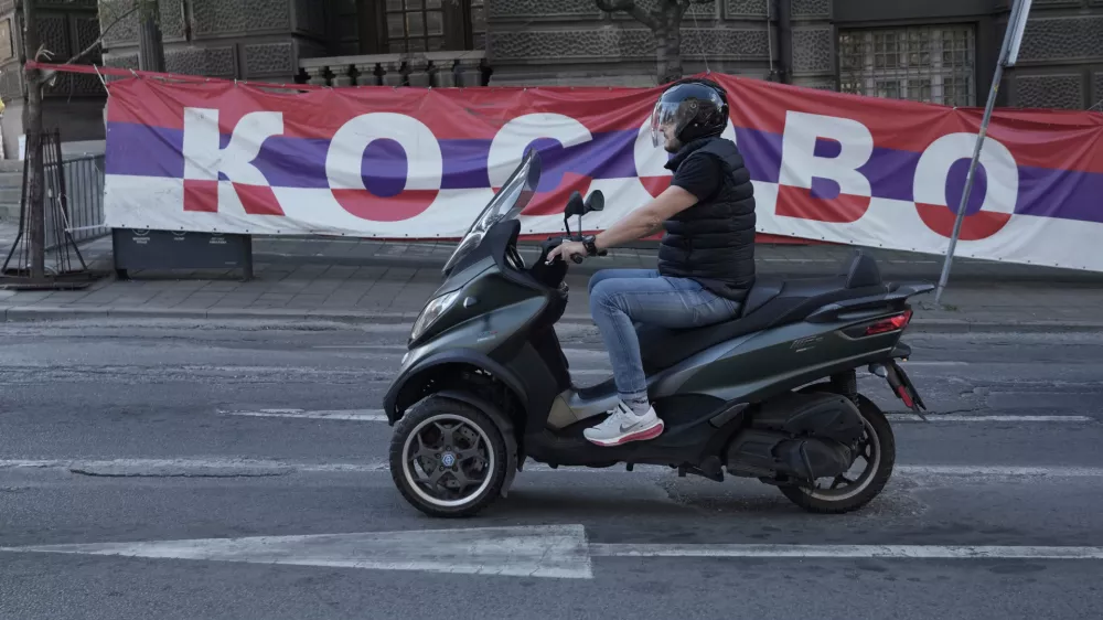 A scooter passes by a billboard reading: ''Kosovo'', placed on a street in front of the government building in Belgrade, Serbia, Thursday, Sept. 18, 2025. (AP Photo/Darko Vojinovic)