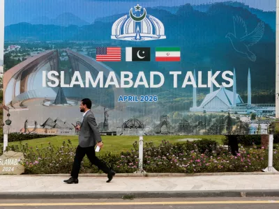 A man walks past a billboard near the media centre as delegations from the United States and Iran are expected to hold high-stakes talks in Islamabad, Pakistan, April 11, 2026. REUTERS/Asim Hafeez   TPX IMAGES OF THE DAY