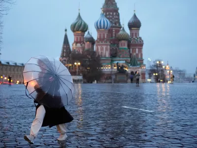 A woman holds an umbrella while she walks through Red Square as it drizzles in Moscow, Thursday, April 9, 2026. (AP Photo/Pavel Bednyakov)