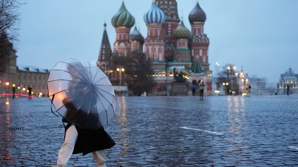A woman holds an umbrella while she walks through Red Square as it drizzles in Moscow, Thursday, April 9, 2026. (AP Photo/Pavel Bednyakov)